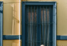 man and woman standing in front of building s window 3428295 scaled