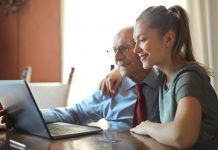 young positive woman helping senior man using laptop 3823489