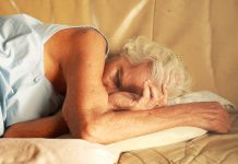 old grey haired woman sleeping on bed scaled