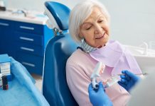 Senior citizen listening to orthodontist explanation of human teeth