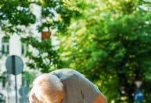 Elderly man suffering from knee pain during his jogging workout